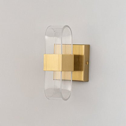 Gold wall light with ribbed clear glass shade shown on a bright white background for accurate product detailing.