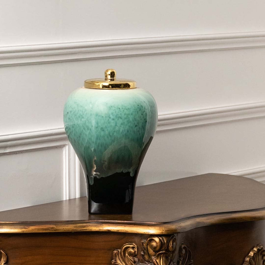 Premium ceramic decorative jar in green and black tones with gold lid crafted for tabletop accent in elegant home decor.