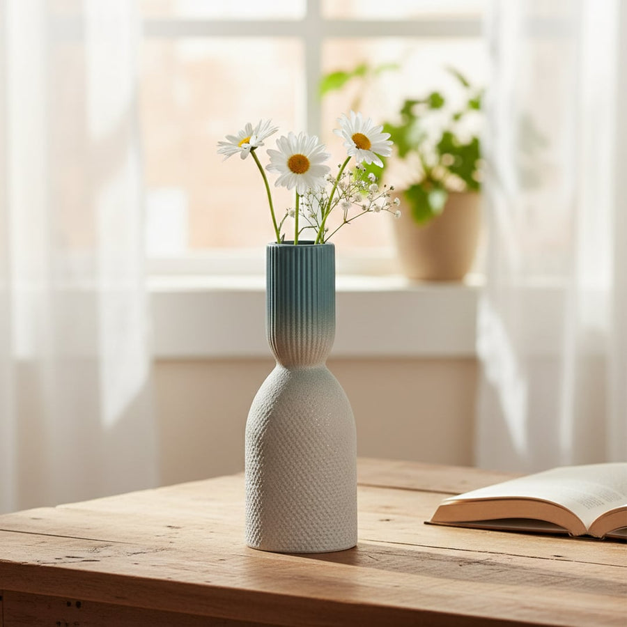 Blue and white ceramic decorative vase with floral stems placed on wooden table adding fresh and modern charm to home decor.