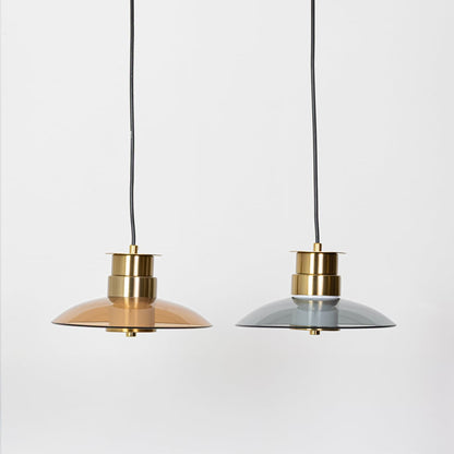 Amber and smoke grey glass pendant lights with gold metal finish shown with lights off together on a neutral background highlighting design contrast.