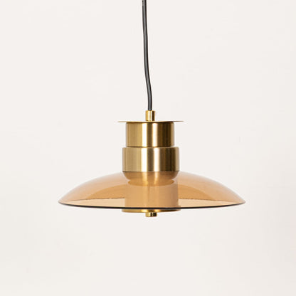 Amber glass pendant light with gold metal detailing displayed with lights off against a clean white background showing its sleek form.