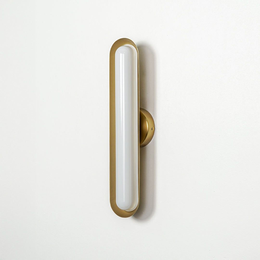 Minimal gold wall light with slim oval LED design mounted on neutral wall background perfect for modern home decor lighting.

