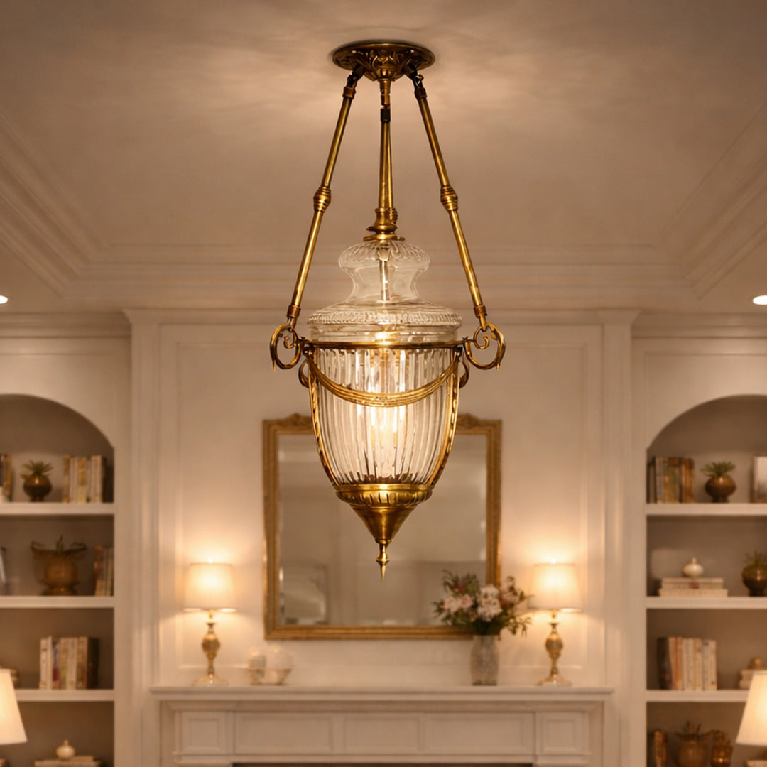 Antique brass and clear glass lantern pendant light creating luxurious ambience in classic interiors.