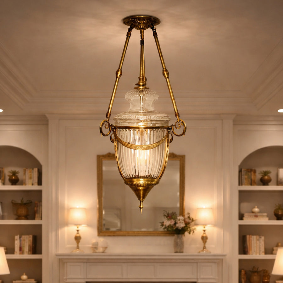 Antique brass and clear glass lantern pendant light creating luxurious ambience in classic interiors.