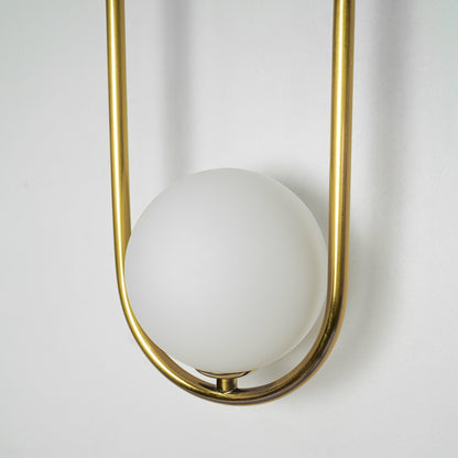 Closeup image of gold metal wall light with frosted globe shade for stylish luxury wall lighting decor.