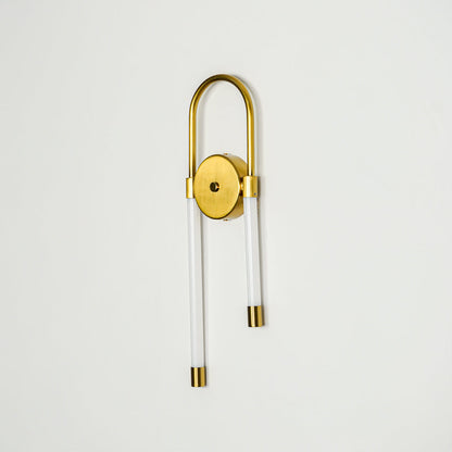 Minimal gold wall light with cylindrical glass shade and pull chain mounted on neutral wall background ideal for modern bedroom or hallway lighting.