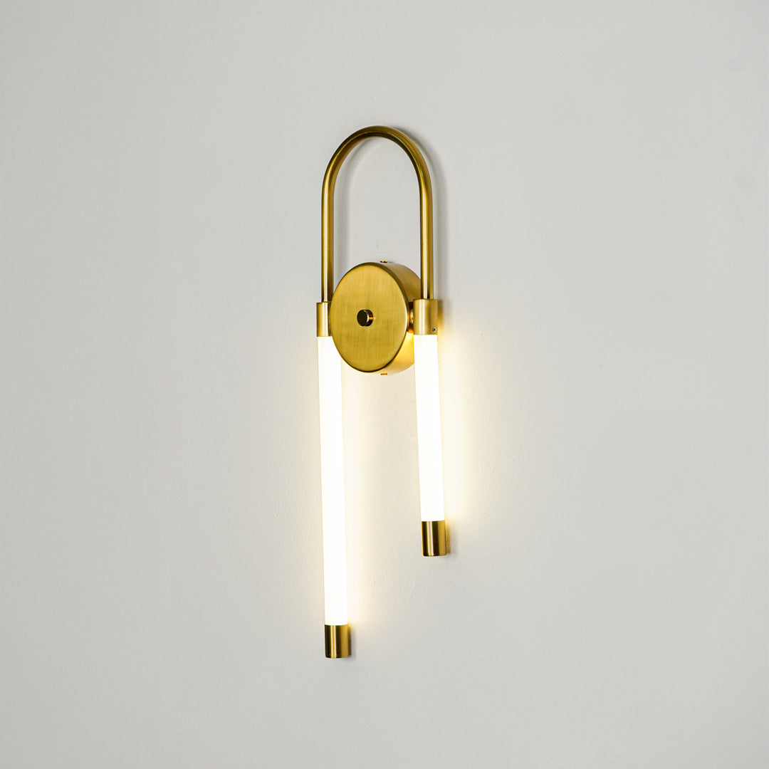 Minimal gold wall sconce with cylindrical white glass shades on clean background perfect for modern interior accent lighting setup.

