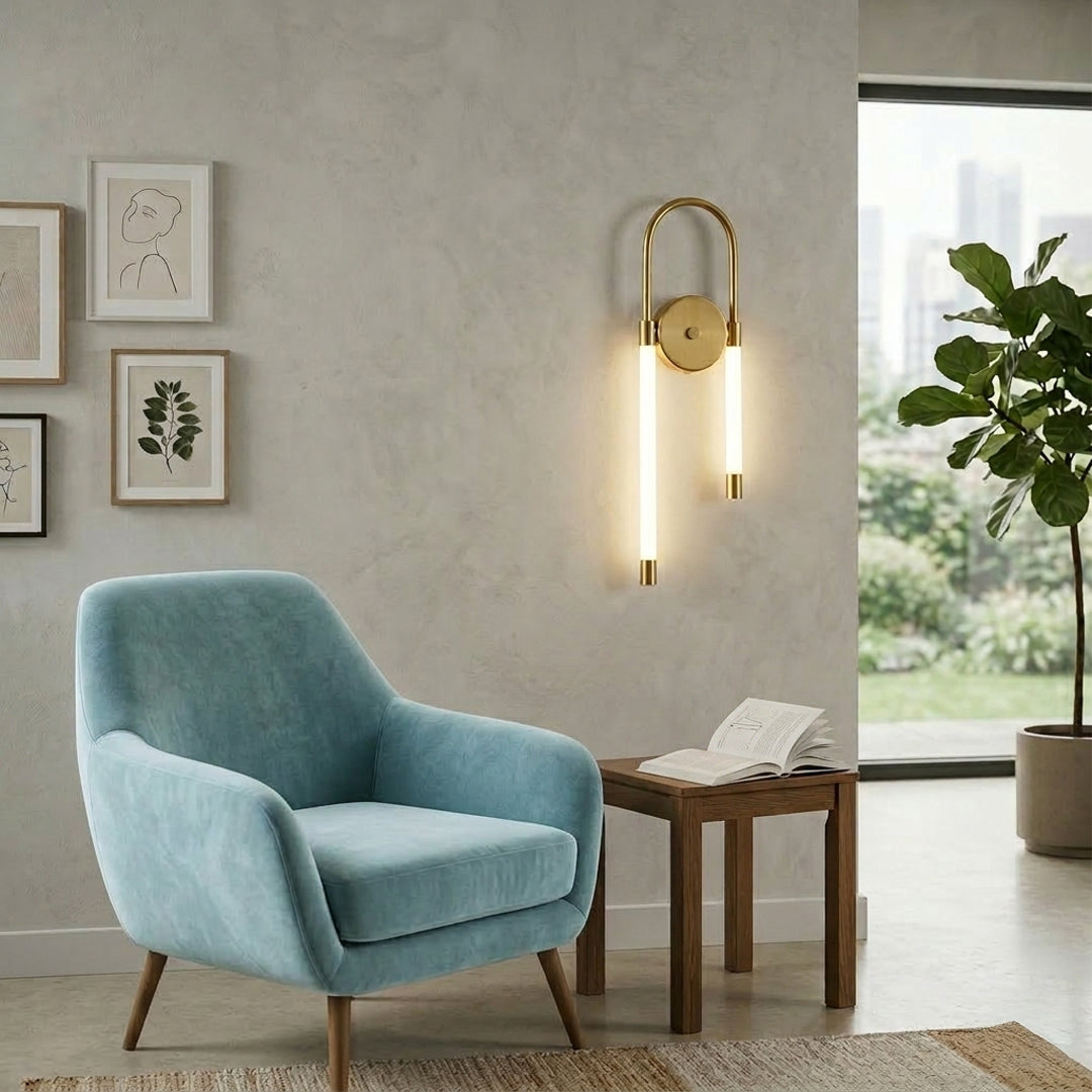 Gold wall light with looped LED tube mounted on neutral wall beside blue armchair and wooden table ideal for modern living room decor.