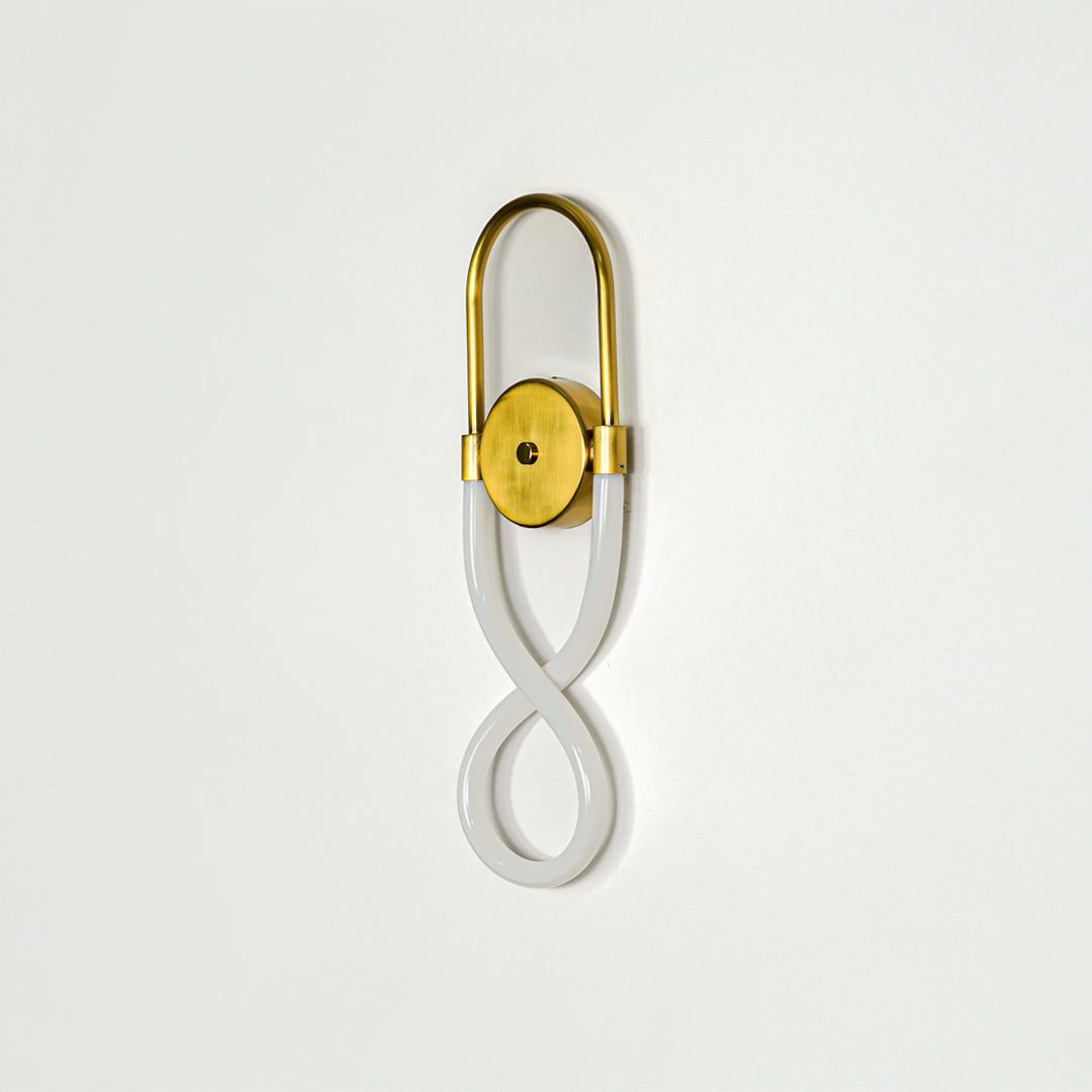 Elegant gold wall sconce with infinity shape LED tube mounted on soft neutral wall background perfect for modern decorative lighting setup.