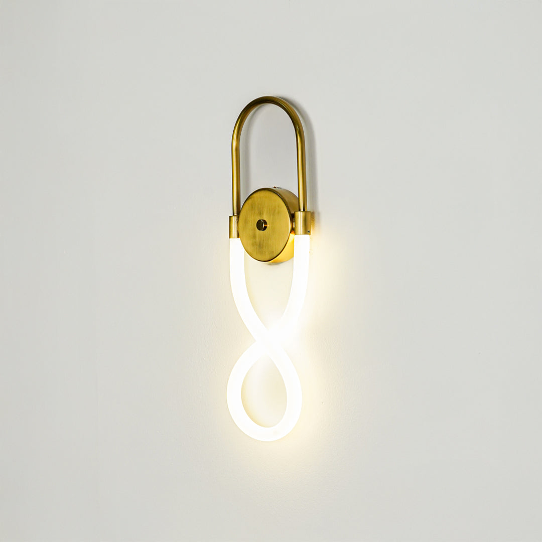 Minimal gold wall light with glowing loop LED tube on clean neutral wall background ideal for stylish bedroom or hallway decor lighting.