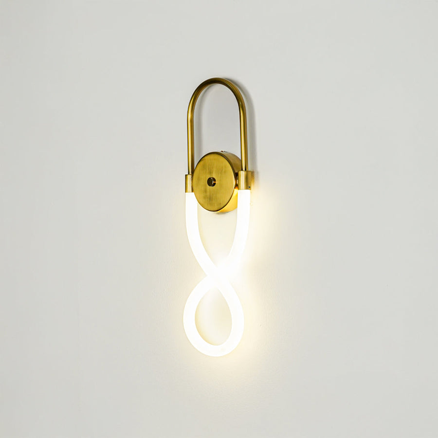 Minimal gold wall light with glowing loop LED tube on clean neutral wall background ideal for stylish bedroom or hallway decor lighting.