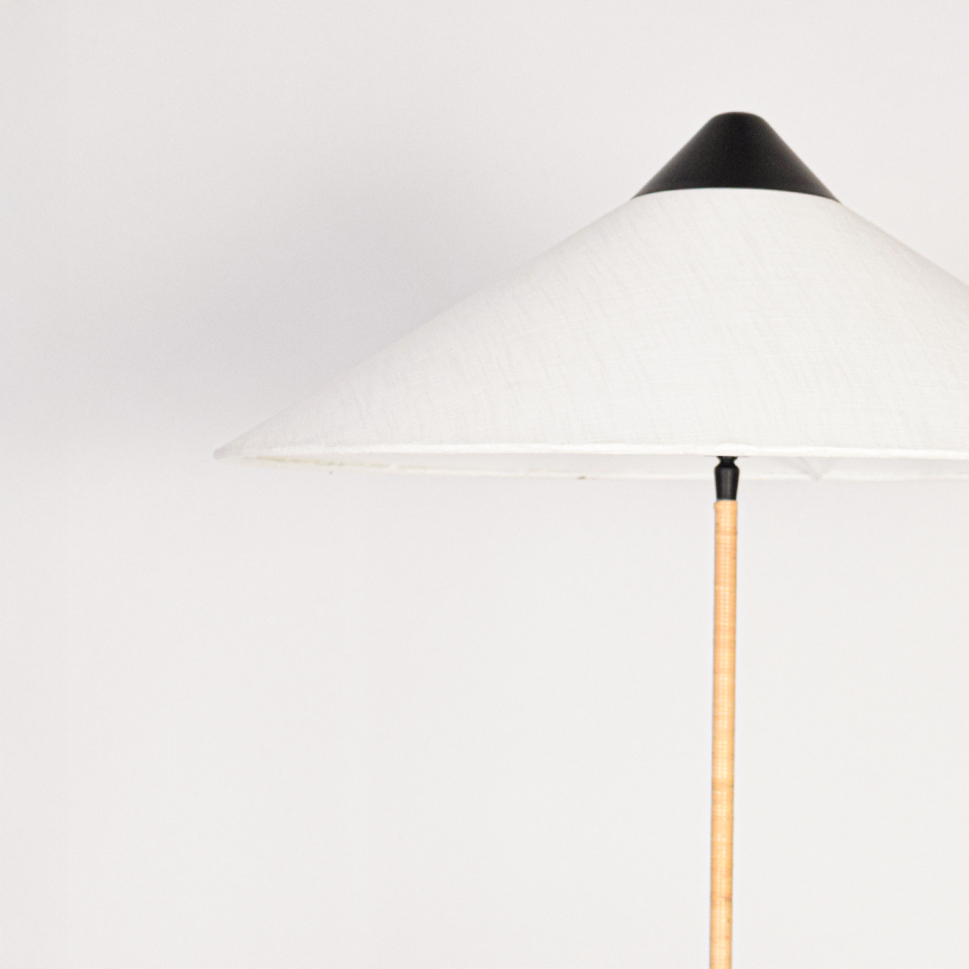Closeup of floor lamp stacked turned base with smooth finish highlighting craftsmanship texture and elegant detailing under soft ambient lighting.