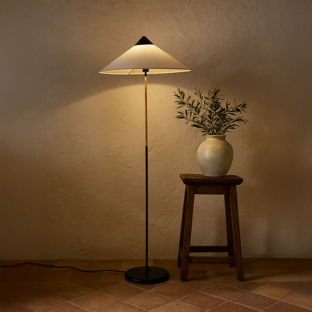 Modern floor lamp styled beside sofa and side table creating warm ambient glow in minimalist living room with soft rug neutral walls and natural decor.