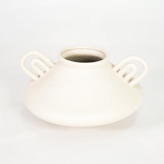 White ceramic vase with loop handles for modern shelf placement and elegant indoor home decor styling accent.