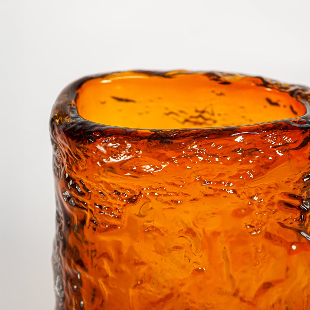 Close up view amber textured art glass vase showing sculpted surface glossy finish decorative glass accent for shelf styling.