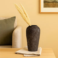 Lifestyle image of black ceramic floor vase for modern living room decor styling with textured matte finish.