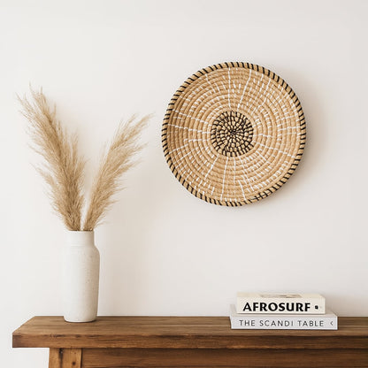 Natural woven wall basket displayed on a wooden shelf for elegant bohemian wall decor and modern home interiors.