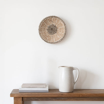 Natural woven decorative wall basket with minimalist spiral design for elegant wall styling and modern home decor.