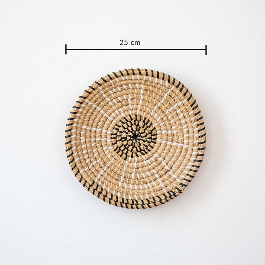 Decorative wall basket handwoven in natural cane with black details measuring 25 cm diameter for wall decor.