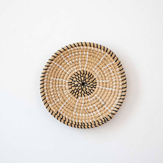 Handwoven seagrass round wall basket decor in natural beige with open weave center displayed flat on white background.