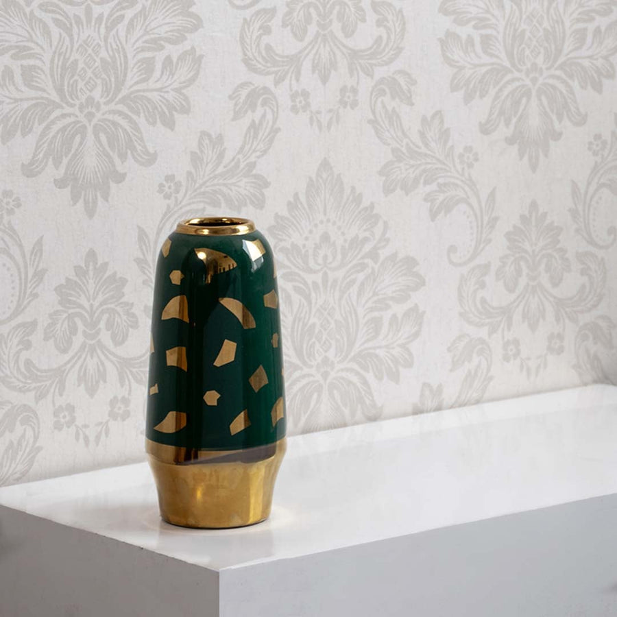 Green and gold ceramic decorative vase placed on a white surface showcasing glossy finish and modern home decor styling.