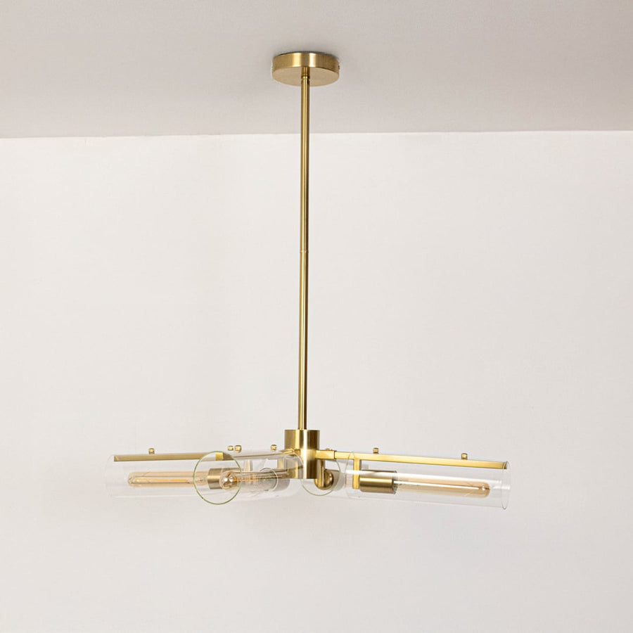 Gold molecular chandelier with clear glass tube shades turned off on white background displaying modern industrial fixture.