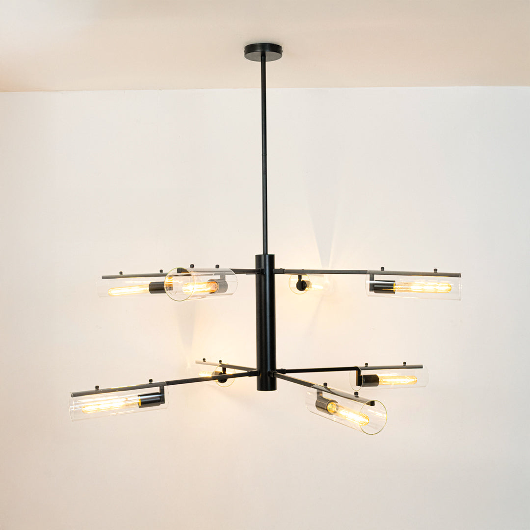 Black metal chandelier with illuminated crystal tube shades creating sophisticated modern ambient lighting for interiors.