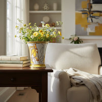 White and gold ceramic decorative vase styled with flowers beside a sofa for elegant contemporary home decor settings.