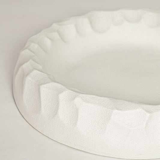 White ceramic decorative bowl with sculpted textured rim perfect for elegant dining table centerpiece and interior decor styling.