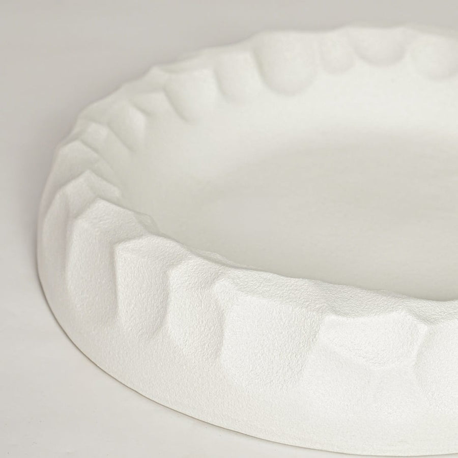 White ceramic decorative bowl with sculpted textured rim perfect for elegant dining table centerpiece and interior decor styling.