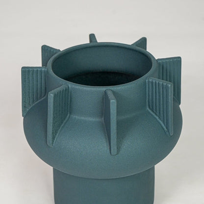 Green ceramic flower vase closeup with textured pattern modern decorative vase for shelf console table decor styling.