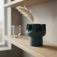 Green ceramic flower vase placed on wooden shelf modern decorative vase for living room decor styling.