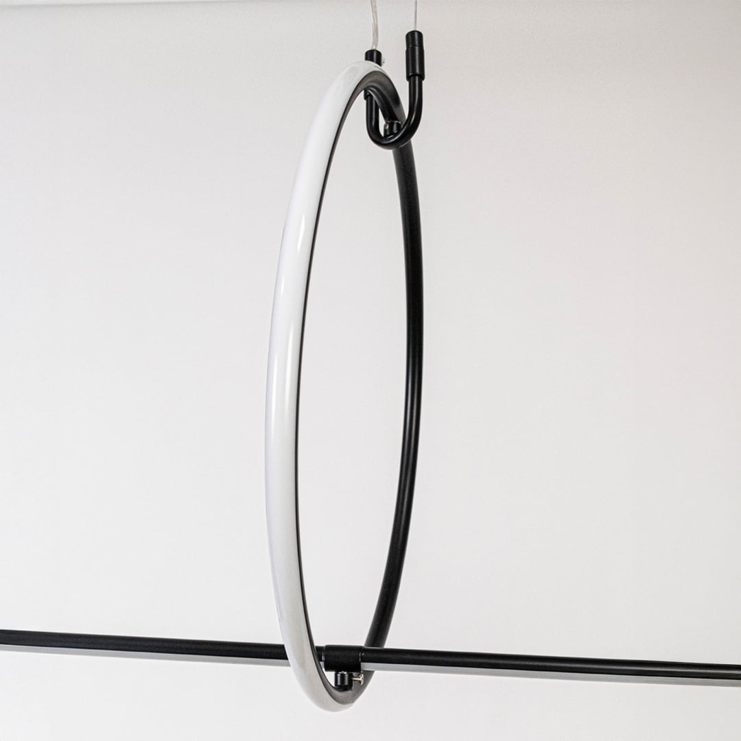 Closeup of slim black linear pendant light showing minimalist rod design and refined modern details.