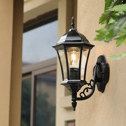 Outdoor black wall light enhancing the exterior of a modern home entrance with bright warm illumination.