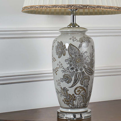 Closeup view of the ceramic lamp showcasing intricate floral patterns and smooth glazed finish with soft light reflecting across the surface.