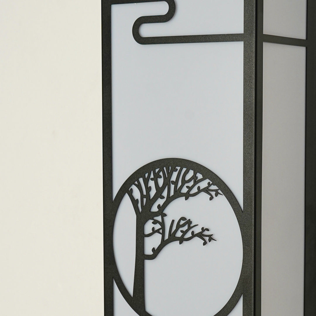 Close view of decorative outdoor wall light with tree pattern metal design and glass panel showcasing modern exterior lighting style.