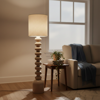 Lifestyle scene showing modern black floor lamp beside cozy armchair and side table near window adding warm ambient glow to living room decor.