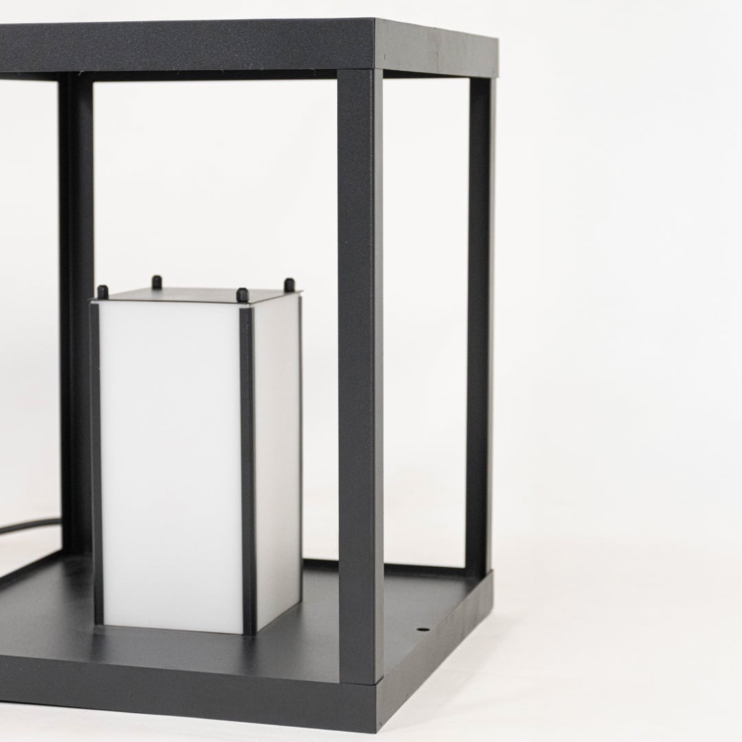 Closeup of modern black metal lantern showing open frame structure clean edges and minimalist decorative lighting design detail.