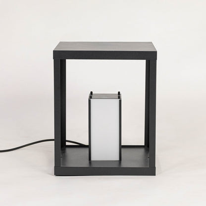 Minimalist table lamp with black frame and frosted white shade displayed off on plain white background.