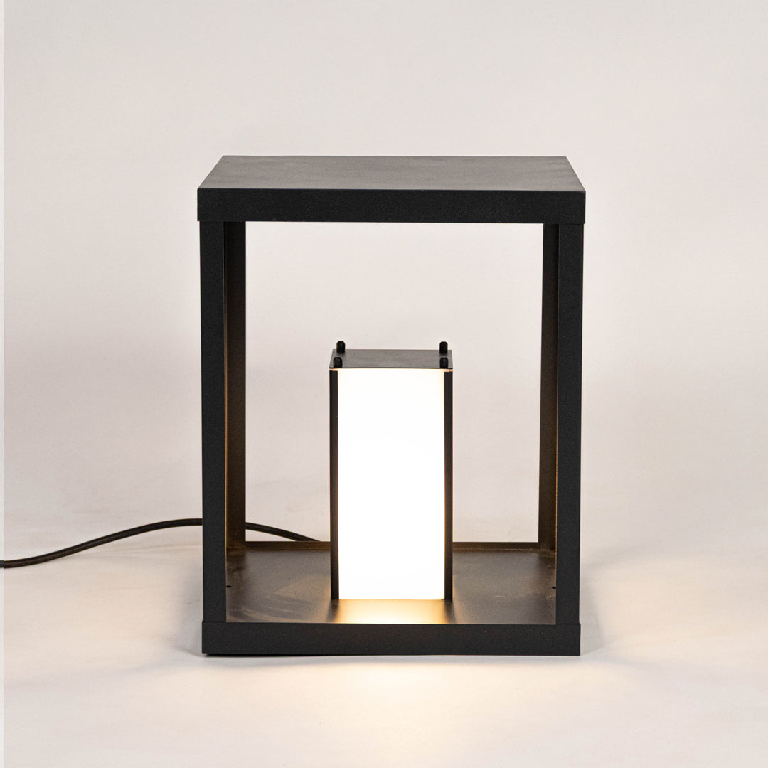 Modern black outdoor wall light with warm glowing panels for stylish exterior decor use.