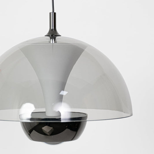 A closeup view of the smoked grey dome pendant showing the smooth reflective surface and curved shape with soft detailing in a minimal setting.