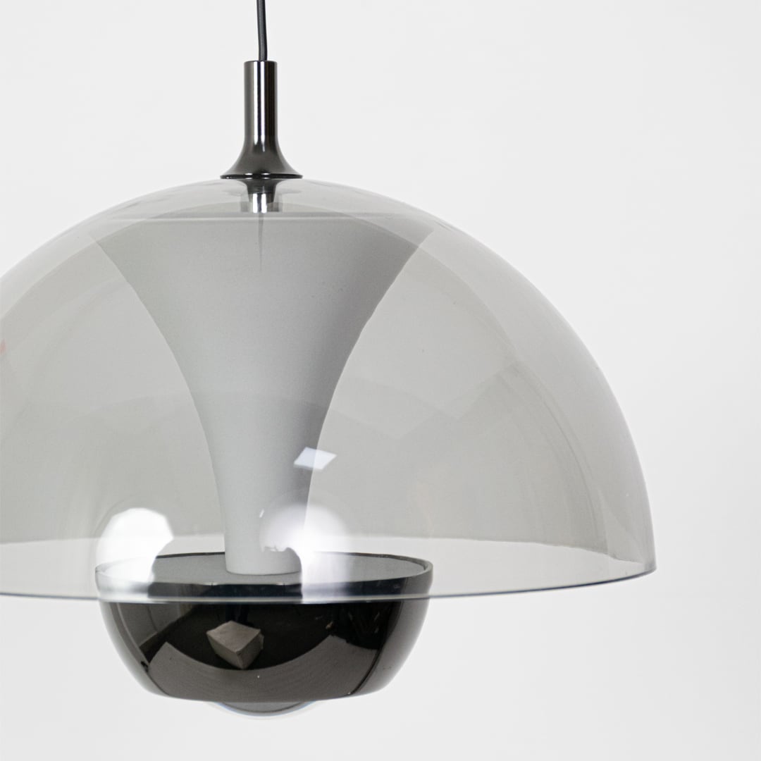 A closeup view of the smoked grey dome pendant showing the smooth reflective surface and curved shape with soft detailing in a minimal setting.