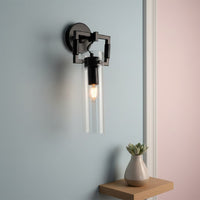 Modern black metal wall light with glass tube shade for stylish bedroom and contemporary hallway decor spaces.

