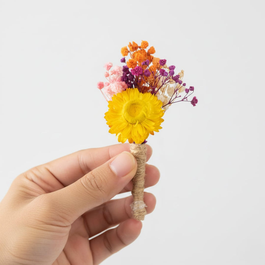 Decorative dried flower bunch with bright yellow orange and purple blooms styled on white background for home decor accents.