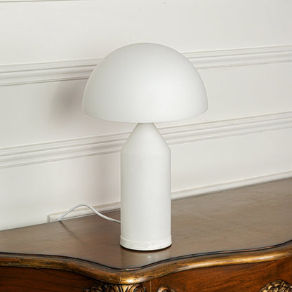 Contemporary white table lamp with mushroom shape design on wooden table ideal for modern bedroom or living room lighting.

