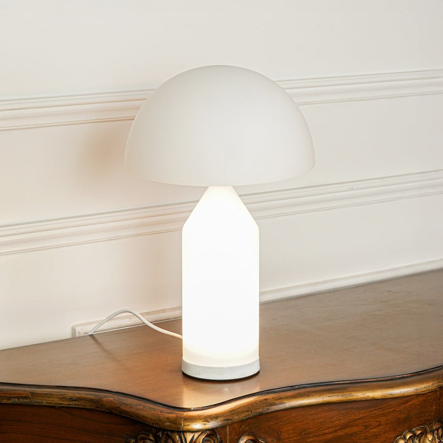 Close view of white table lamp with dome shade and smooth base on neutral background ideal for modern home decor lighting.