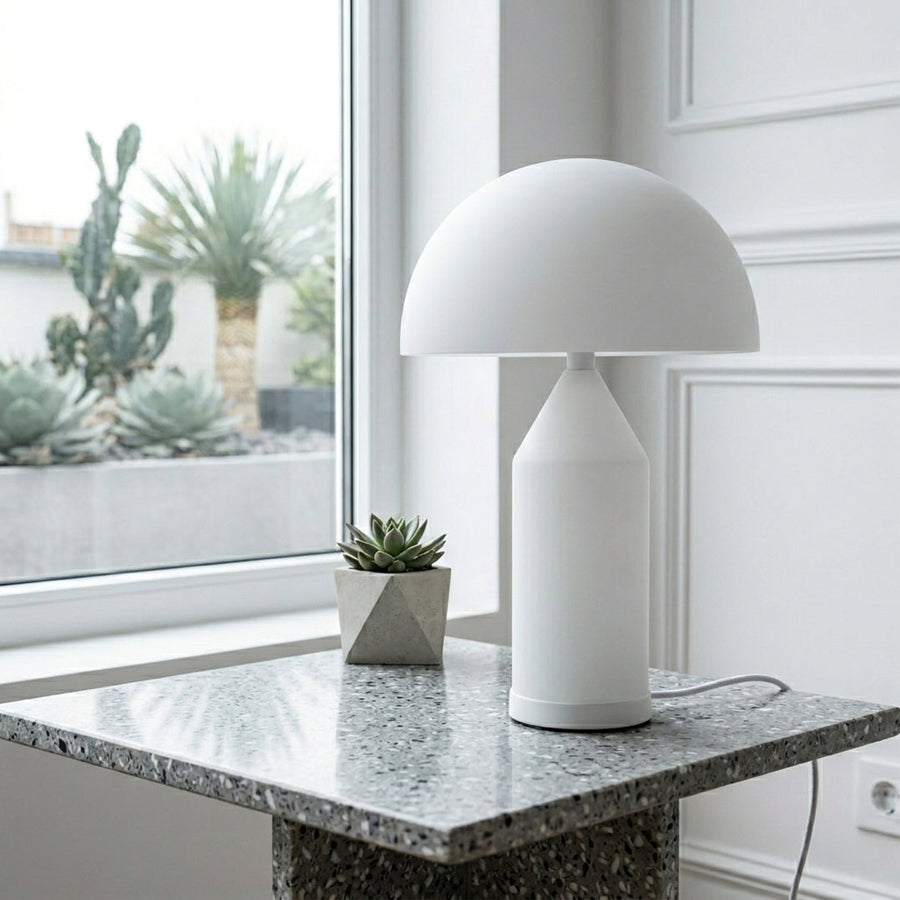Table lamp with white dome shade and solid base placed on marble countertop ideal for modern kitchen or living room decor lighting.