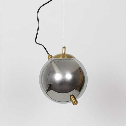An amber tinted globe pendant light with its internal rod light turned off shown on a white background highlighting its smooth rounded form.