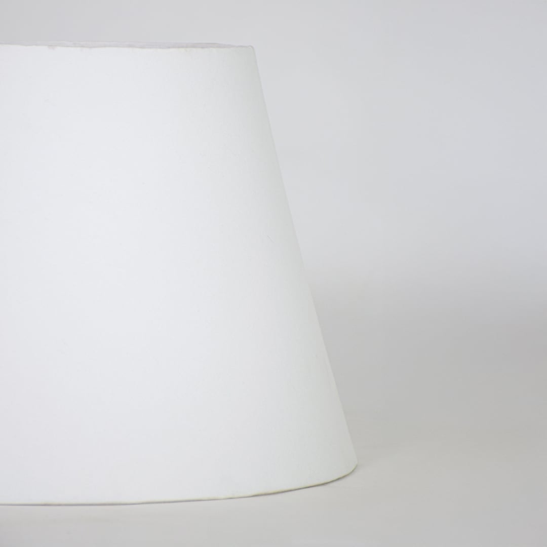White fabric lamp shade with tapered modern design for elegant tabletop lighting decor placement styling.