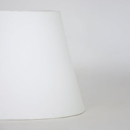 White fabric lamp shade with tapered modern design for elegant tabletop lighting decor placement styling.